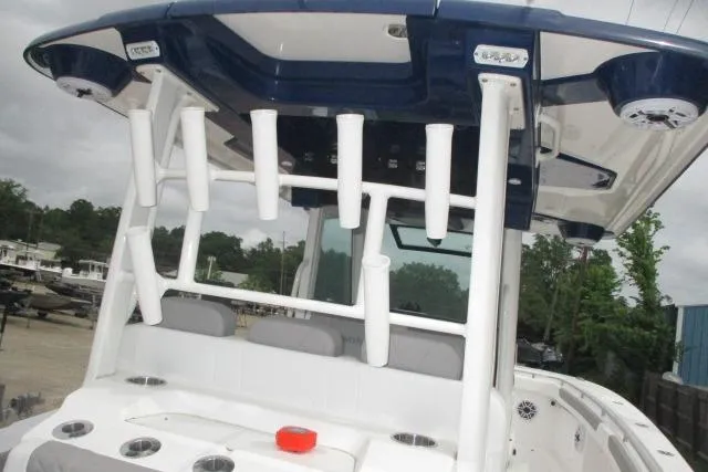 Slide: The Image of 2024 Caymas 30CAT boat with rod holders and seating under a blue canopy. - 13