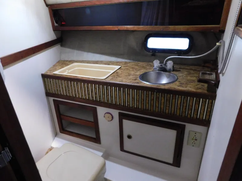 Slide: The Image of 1984 Cruisers International 296 Avanti Vee boat bathroom with sink, countertop, and toilet. - 12