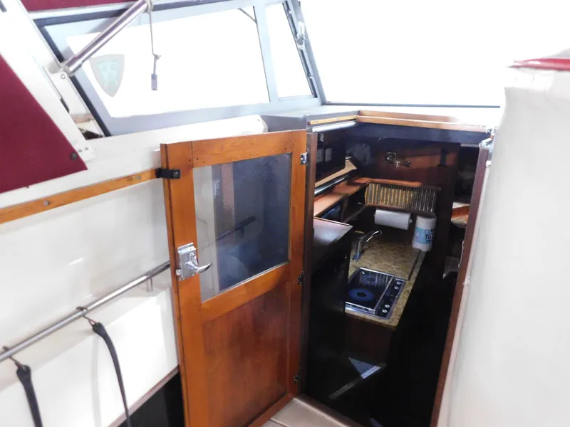 Slide: The Image of 1984 Cruisers International 296 Avanti Vee cabin interior with wooden door and kitchenette. - 13