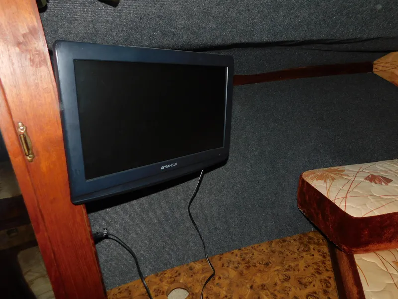 Slide: The Image of Interior of 1984 Cruisers International 296 Avanti Vee with mounted TV and cushioned seating. - 9