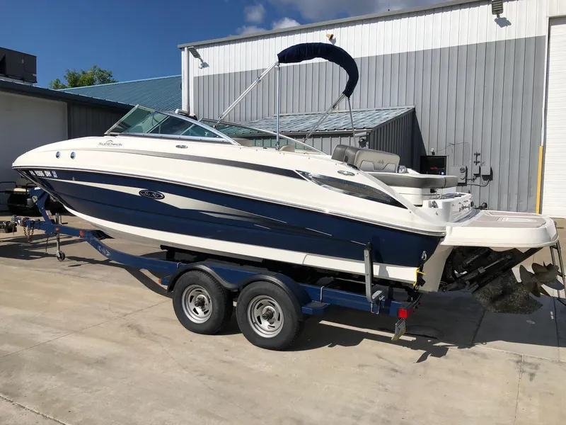 Slide: The Image of 2012 Sea Ray 240 Sundeck boat on trailer, parked outdoors. - 2