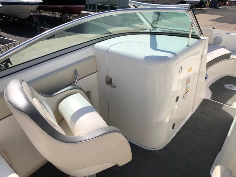 Slide: The Image of 2012 Sea Ray 240 Sundeck interior with white seating and sleek dashboard design. - 7