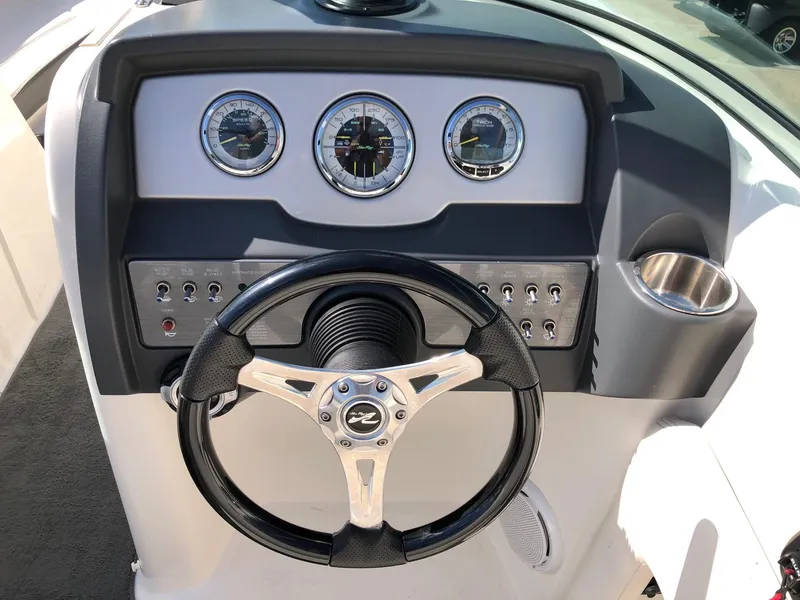 Slide: The Image of 2012 Sea Ray 240 Sundeck dashboard with steering wheel and gauges. - 9