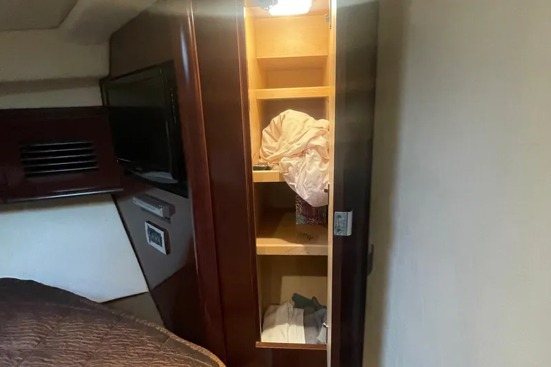 Slide: The Image of Open closet in 2009 Sea Ray 40 Sundancer yacht cabin, showing shelves and bedding. - 25