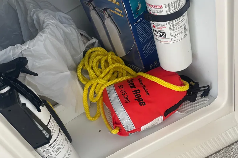 Slide: The Image of Safety equipment storage on 2009 Sea Ray 40 Sundancer, featuring throw rope and fire extinguisher. - 41