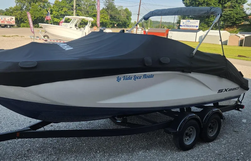 Slide: The Image of 2023 Yamaha SX220 boat covered on trailer, parked outdoors. - 17