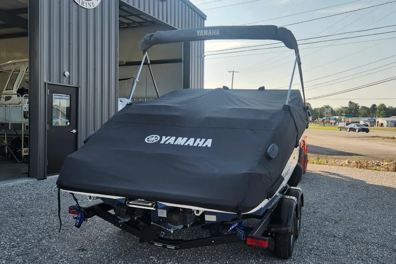 Slide: The Image of 2023 Yamaha SX220 boat with cover, parked outside a building. - 18