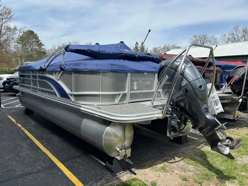Slide: The Image of 2024 Bennington 22SSRSR pontoon boat with blue cover and outboard motor. - 3