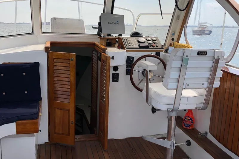 Slide: The Image of 1987 Harris Cuttyhunk Down East boat interior with helm, wooden accents, and navigation equipment. - 14