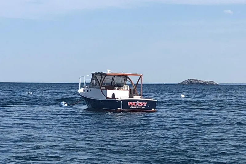 Slide: The Image of 1987 Harris Cuttyhunk Down East boat on calm sea with distant island. - 18