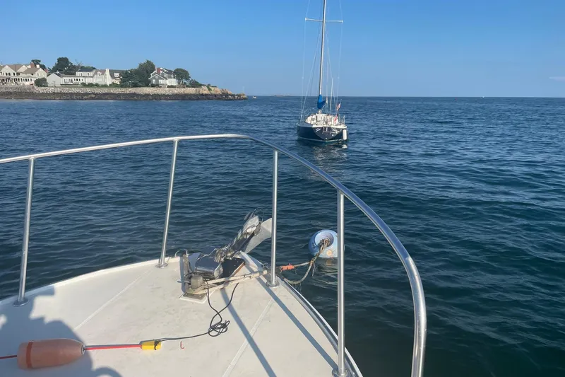 Slide: The Image of 1987 Harris Cuttyhunk Down East boat on calm sea near coastal homes. - 22