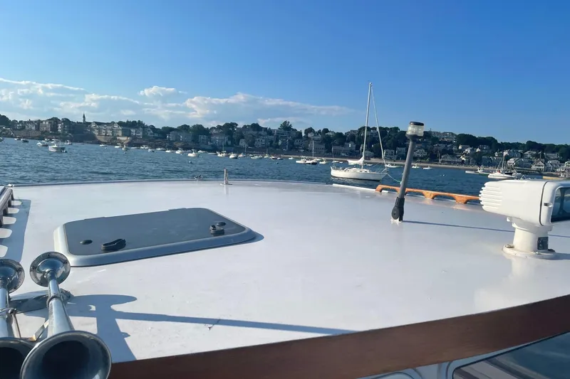 Slide: The Image of 1987 Harris Cuttyhunk Down East boat on calm water with scenic coastal background. - 23