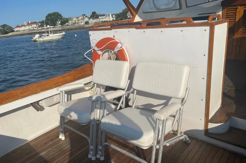 Slide: The Image of Two white chairs on a 1987 Harris Cuttyhunk Down East boat deck. - 25