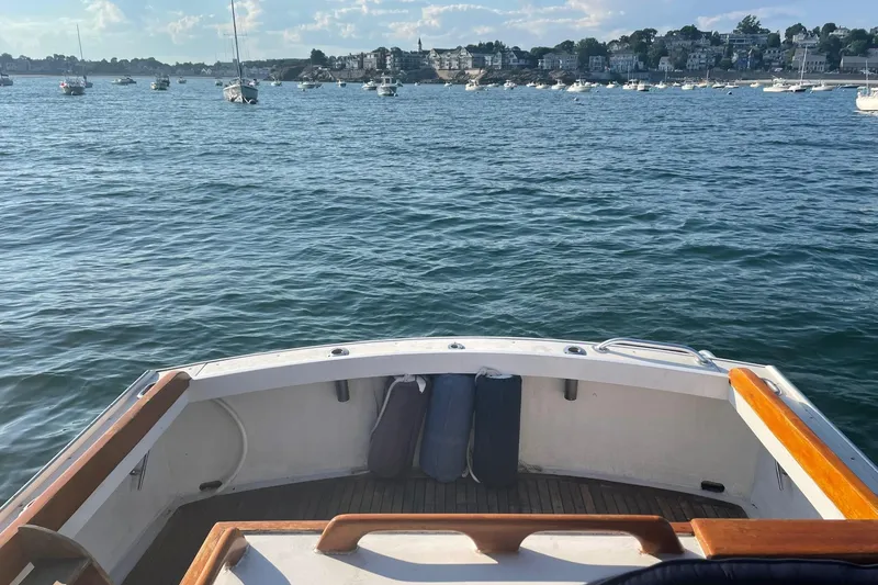 Slide: The Image of 1987 Harris Cuttyhunk Down East boat on calm waters with scenic shoreline view. - 26