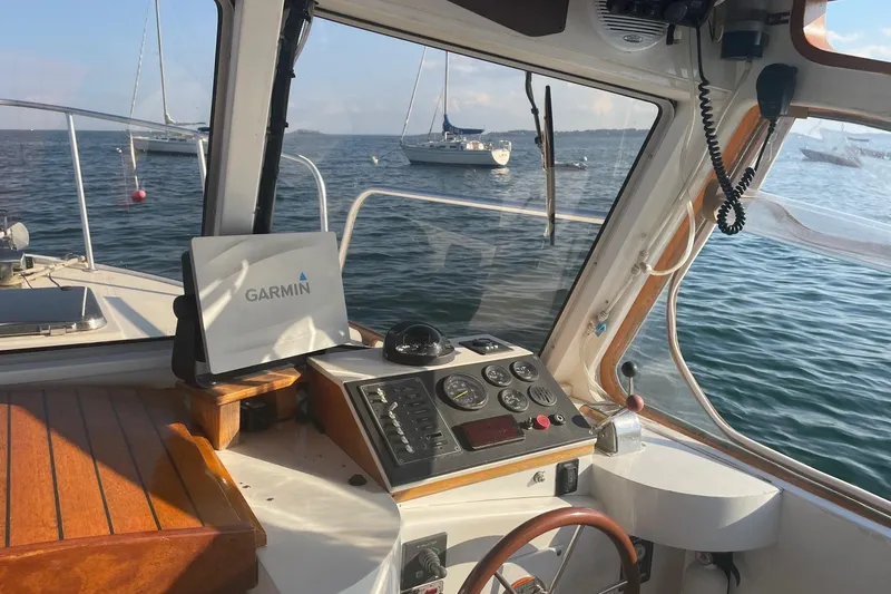 Slide: The Image of 1987 Harris Cuttyhunk Down East boat interior with Garmin navigation, on calm water. - 29