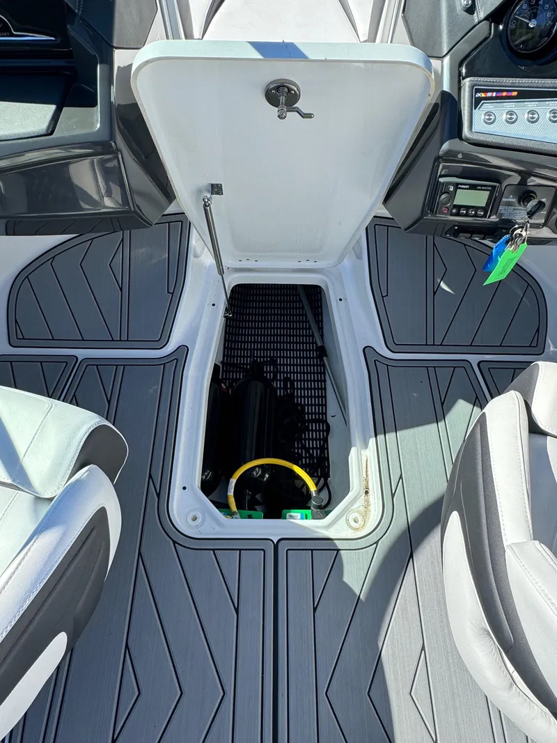 Slide: The Image of 2024 Monterey 218SS boat interior with open storage compartment and modern dashboard. - 13