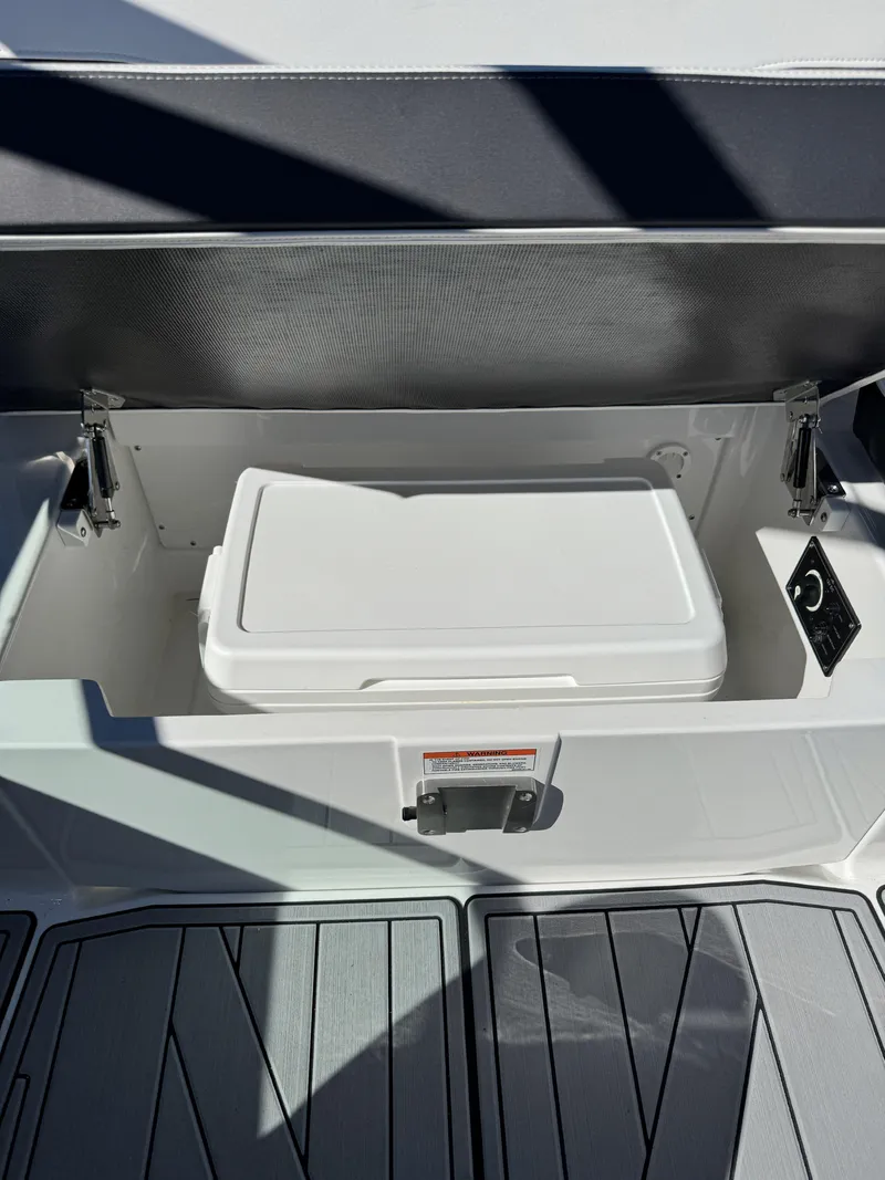 Slide: The Image of 2024 Monterey 218SS boat storage compartment with white cooler inside. - 14