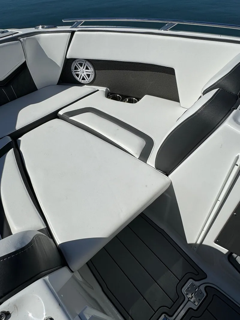Slide: The Image of 2024 Monterey 218SS boat interior with white and black seating, speaker, and cup holders. - 20