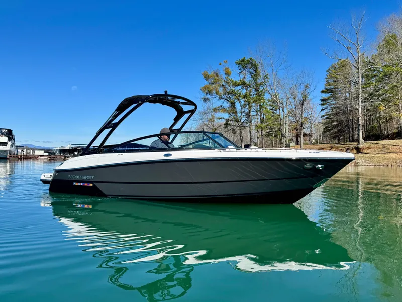 Slide: The Image of 2024 Monterey 218SS boat on a serene lake with clear blue sky. - 4