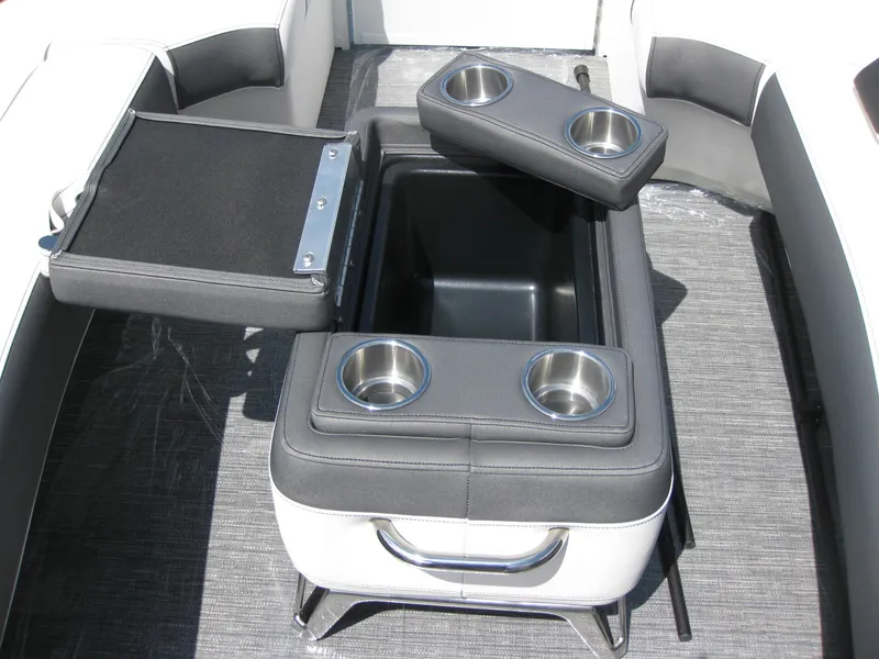 Slide: The Image of 2024 Bennington 25RX Swingback Windshield boat interior with cup holders and storage compartment. - 10