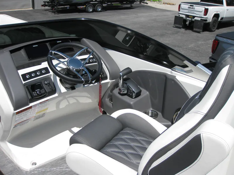 Slide: The Image of 2024 Bennington 25RX Swingback Windshield boat interior with steering wheel and control panel. - 12