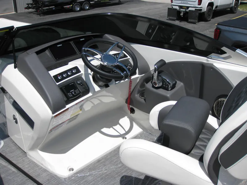 Slide: The Image of 2024 Bennington 25RX Swingback Windshield boat cockpit with steering wheel and controls. - 13