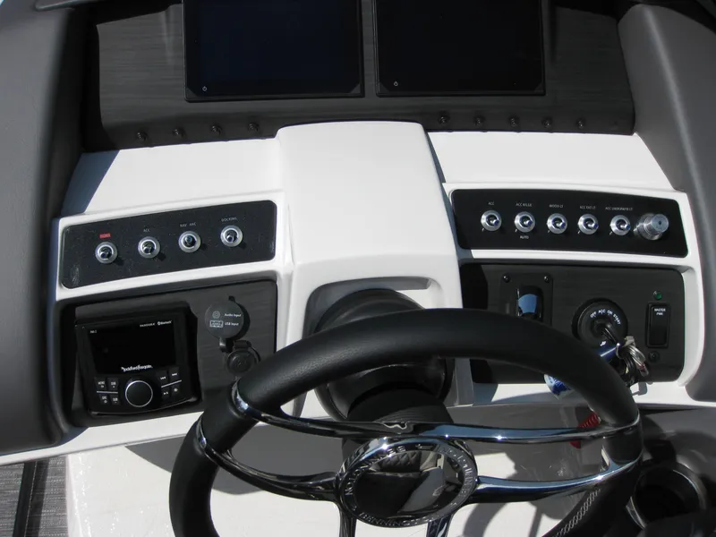 Slide: The Image of 2024 Bennington 25RX Swingback Windshield boat dashboard with steering wheel and control panel. - 21