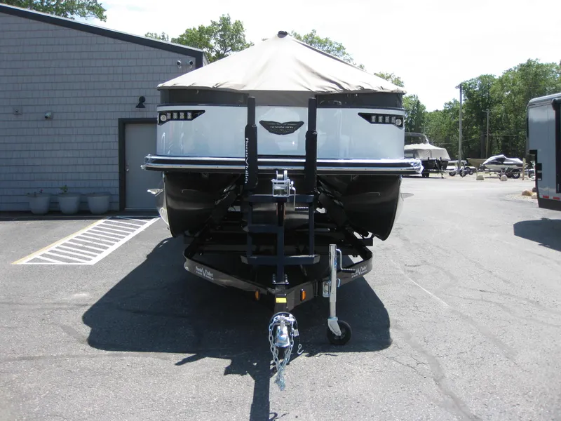 Slide: The Image of 2024 Bennington 25RX Swingback Windshield boat on trailer, parked outdoors. - 6