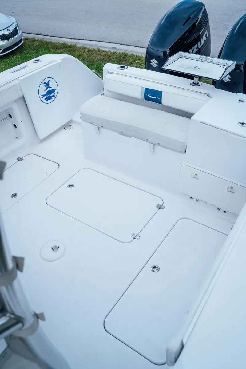 Slide: The Image of 2003 Pro-Line 32 Express boat deck with Suzuki engines, spacious seating, and storage compartments. - 11