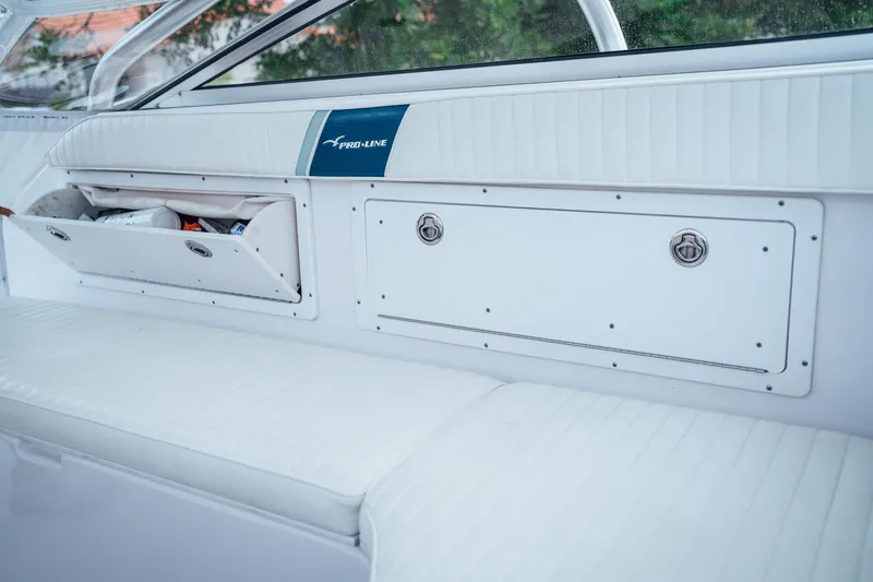 Slide: The Image of 2003 Pro-Line 32 Express boat interior with storage compartments and cushioned seating. - 14