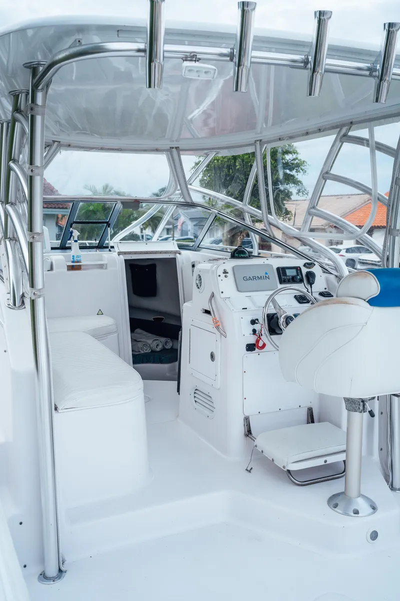 Slide: The Image of 2003 Pro-Line 32 Express boat cockpit with Garmin navigation system and white seating. - 2
