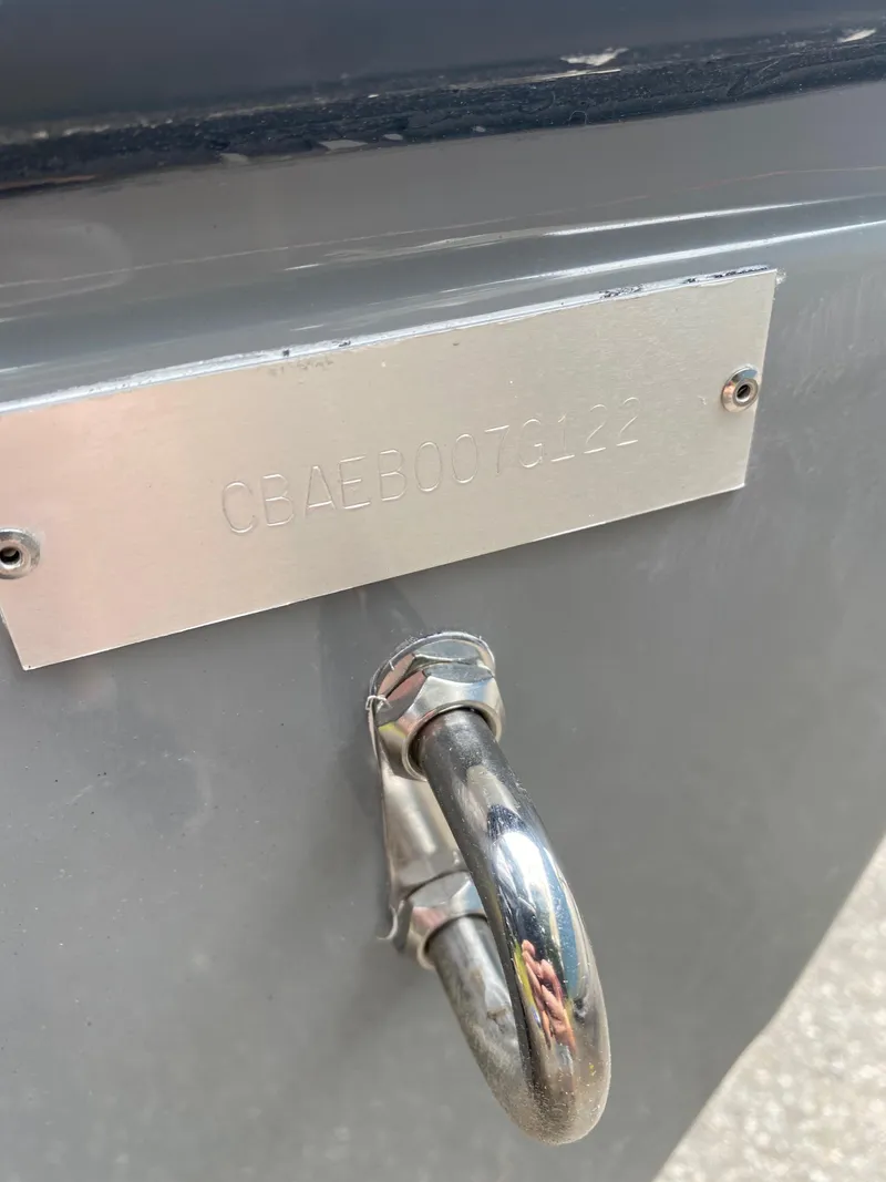 Slide: The Image of 2021 Cobia 240 Center Console boat hull identification plate and metal hook. - 10