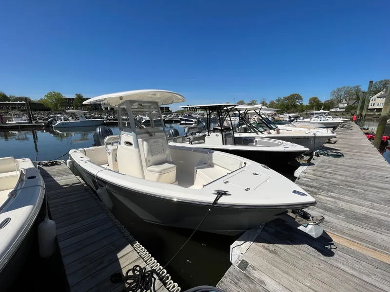 Slide: The Image of 2021 Cobia 240 Center Console boat docked at marina under clear blue sky. - 3