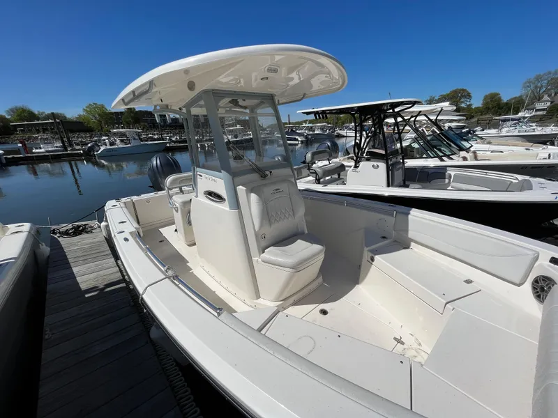 Slide: The Image of 2021 Cobia 240 Center Console boat docked at marina under clear blue sky. - 5
