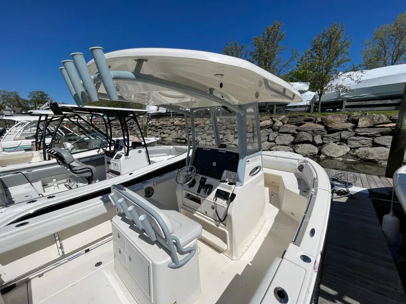 Slide: The Image of 2021 Cobia 240 Center Console boat docked, featuring a sleek design and spacious seating. - 6