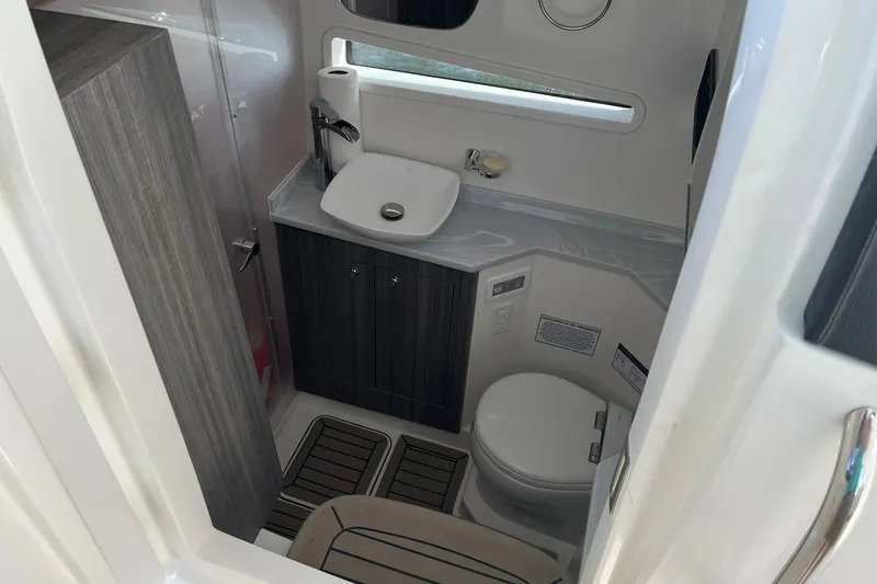 Slide: The Image of Compact bathroom in 2023 World Cat 400 DC-X boat, featuring modern sink and toilet. - 21