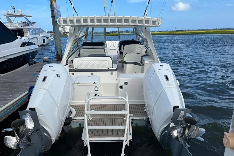 Slide: The Image of 2023 World Cat 400 DC-X boat docked, showcasing spacious seating and dual outboard engines. - 4