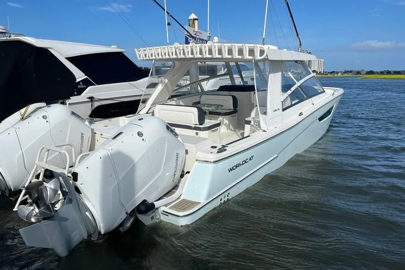 Slide: The Image of 2023 World Cat 400 DC-X boat with dual Mercury engines docked in calm waters. - 5