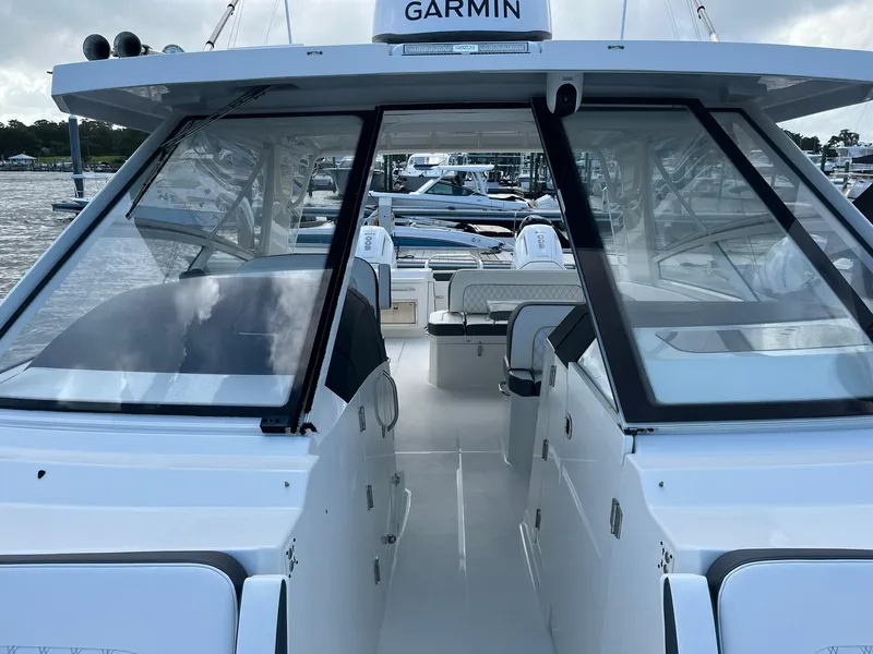 Slide: The Image of 2023 World Cat 400 DC-X boat with sleek design and spacious cockpit, docked at marina. - 8