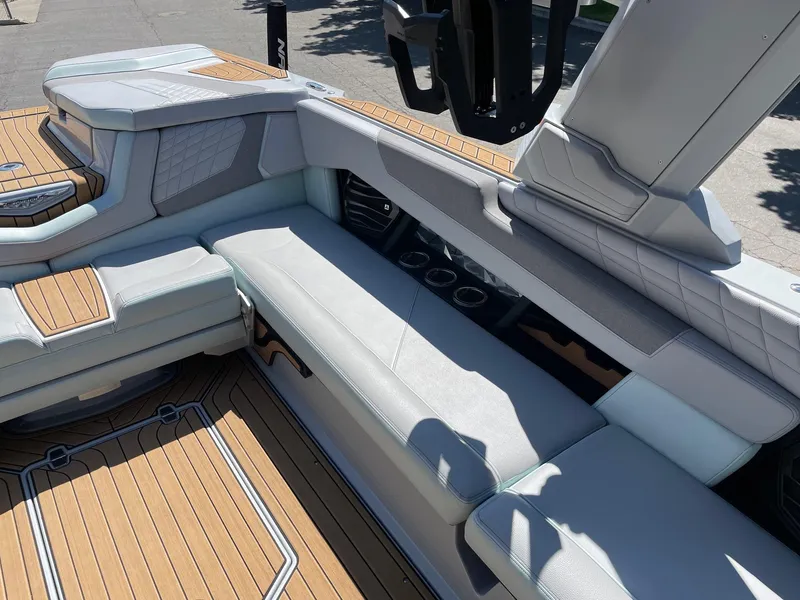 Slide: The Image of 2022 Nautique Super Air Nautique G25 interior with luxurious seating and teak flooring. - 10