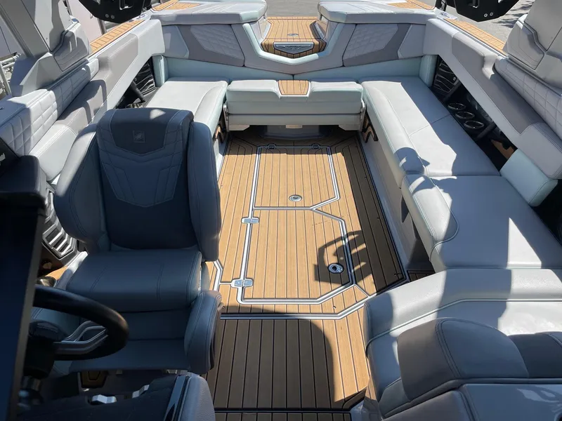 Slide: The Image of 2022 Nautique Super Air Nautique G25 interior with luxurious seating and teak flooring. - 13