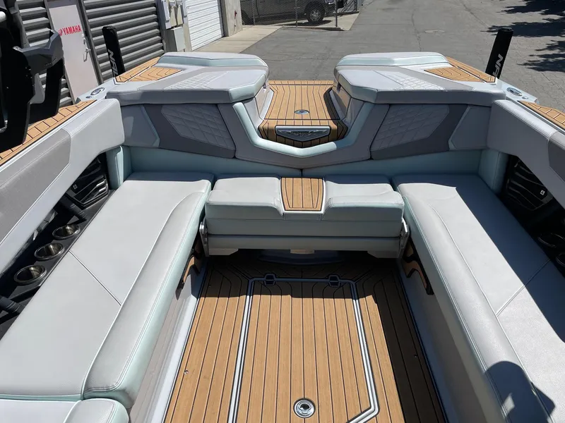 Slide: The Image of 2022 Nautique Super Air Nautique G25 interior with luxurious seating and teak flooring. - 9