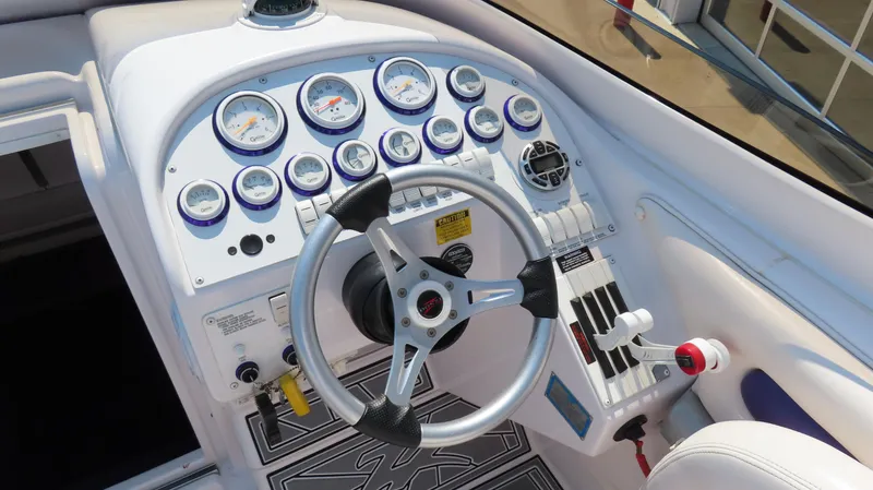 Slide: The Image of 2003 Donzi 28 ZX Open boat dashboard with gauges and steering wheel. - 13