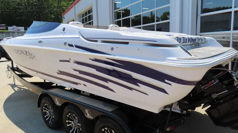 Slide: The Image of 2003 Donzi 28 ZX Open speedboat on trailer, featuring sleek design and purple graphics. - 8