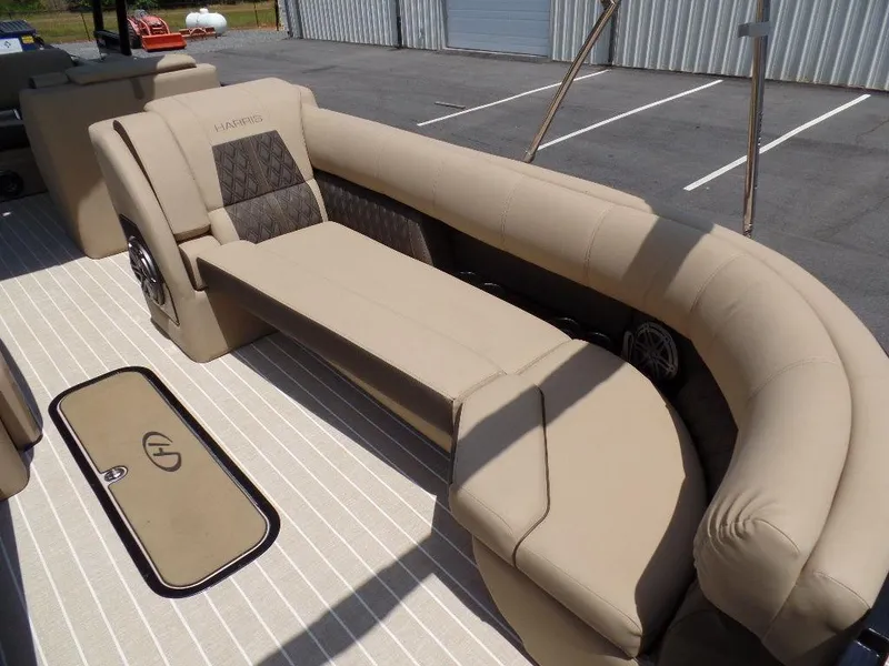 Slide: The Image of 2021 Harris Solstice 250 SL boat interior with beige seating and storage compartment. - 4