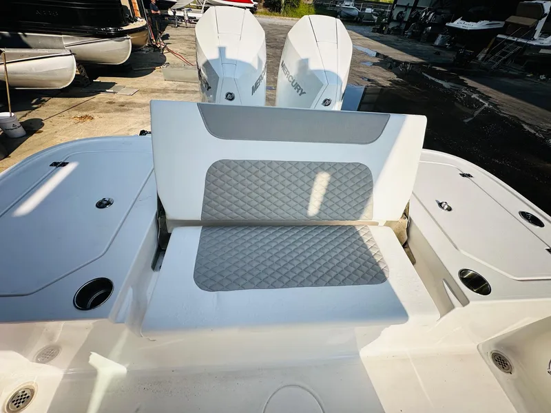 Slide: The Image of 2024 Caymas 281 HB boat with dual Mercury engines and cushioned seating. - 12