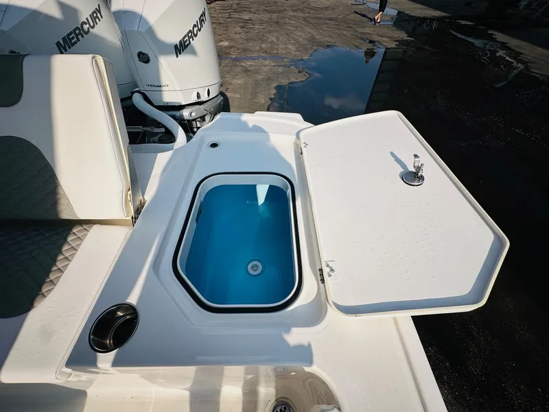 Slide: The Image of 2024 Caymas 281 HB boat with open livewell and Mercury engines in the background. - 13