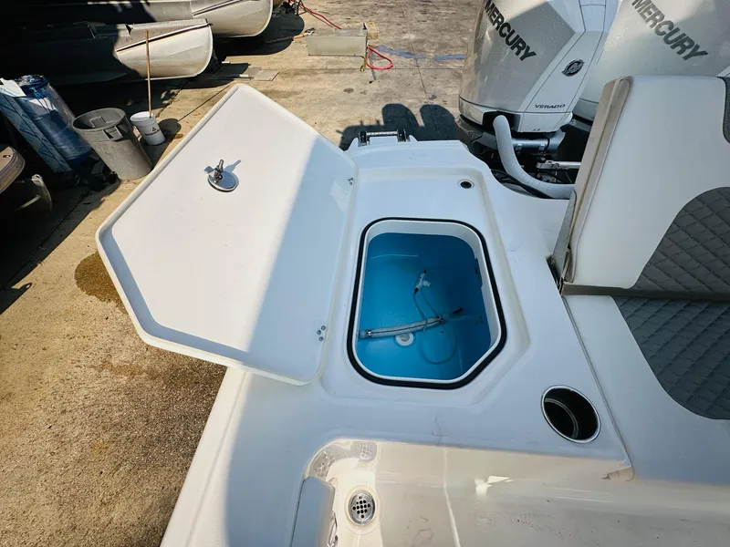 Slide: The Image of 2024 Caymas 281 HB boat with open storage compartment and visible Mercury outboard engines. - 14