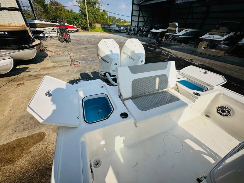 Slide: The Image of 2024 Caymas 281 HB boat with open compartments and dual outboard engines in a marina setting. - 15