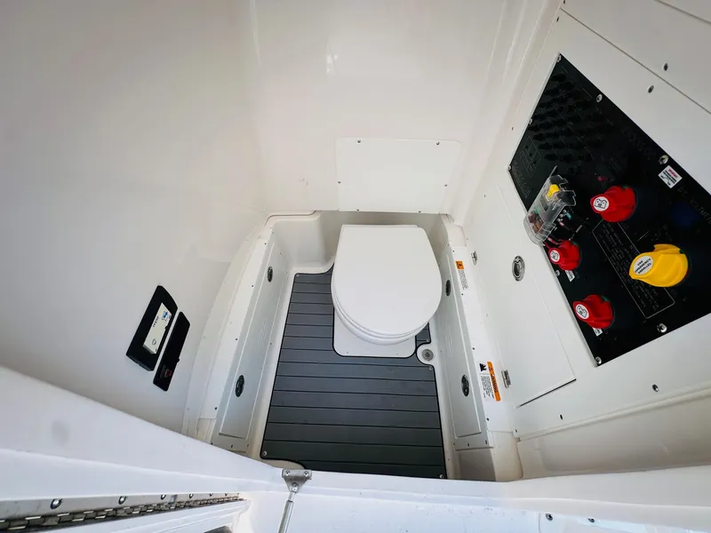 Slide: The Image of 2024 Caymas 281 HB boat interior with compact marine toilet and control panel. - 22